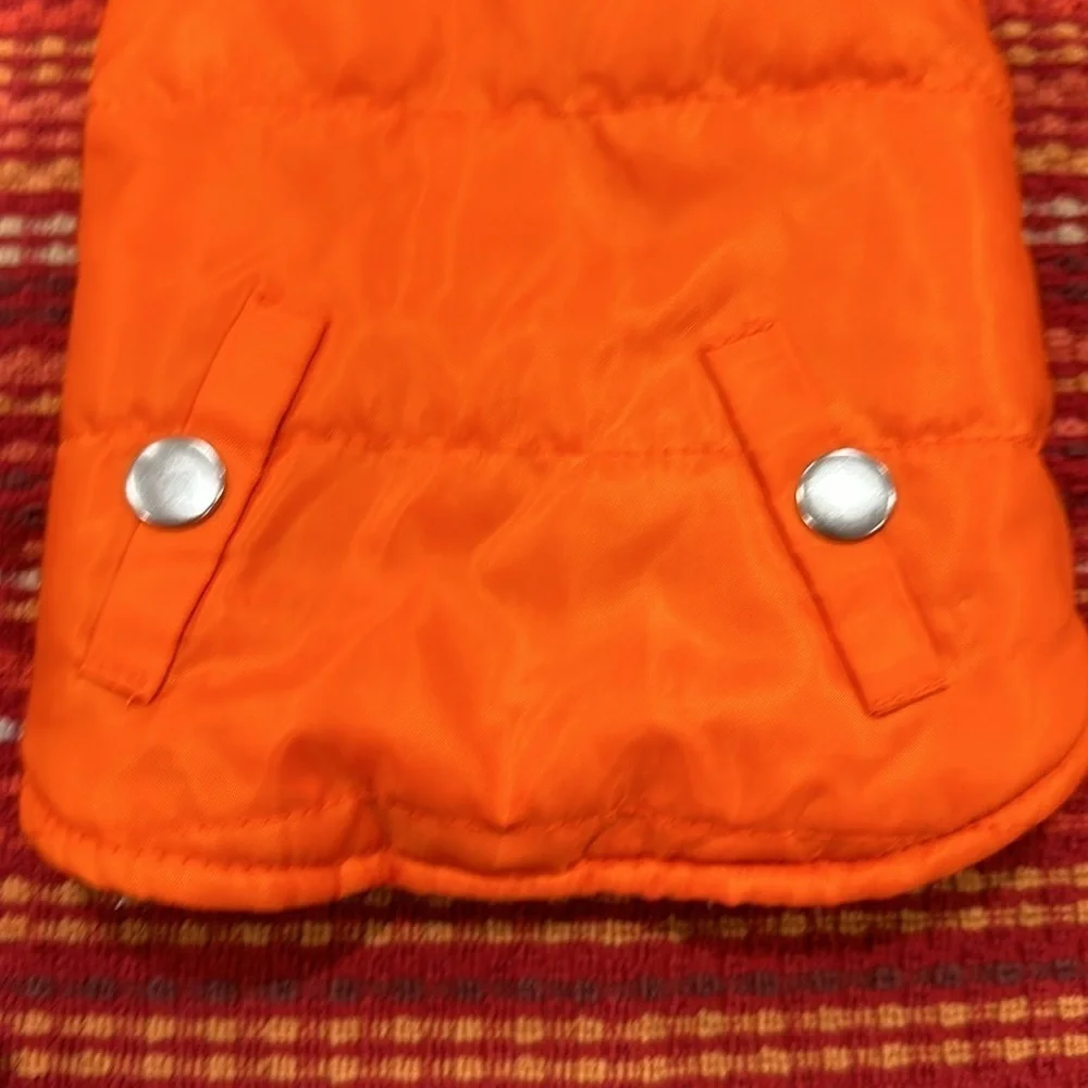 Small orange dog vest pockets are for decoration only.